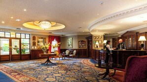 A hotel lobby with a large carpeted area, a reception desk, and a chandelier. - Seven Oaks Hotel with Heated Indoor Pool and Fitness Centre Carlow Town (Carlow)