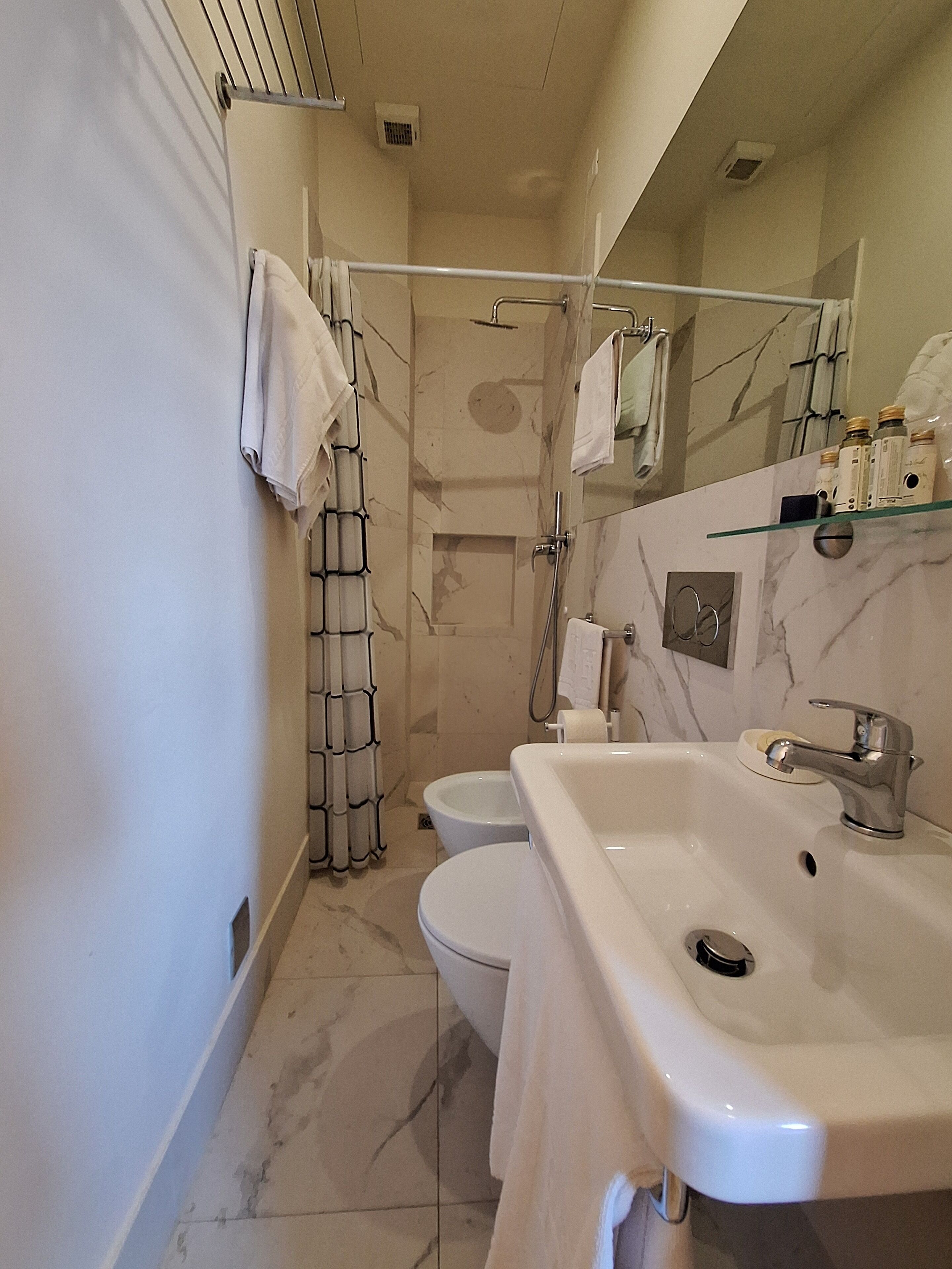 A bathroom with a shower, toilet, and sink.