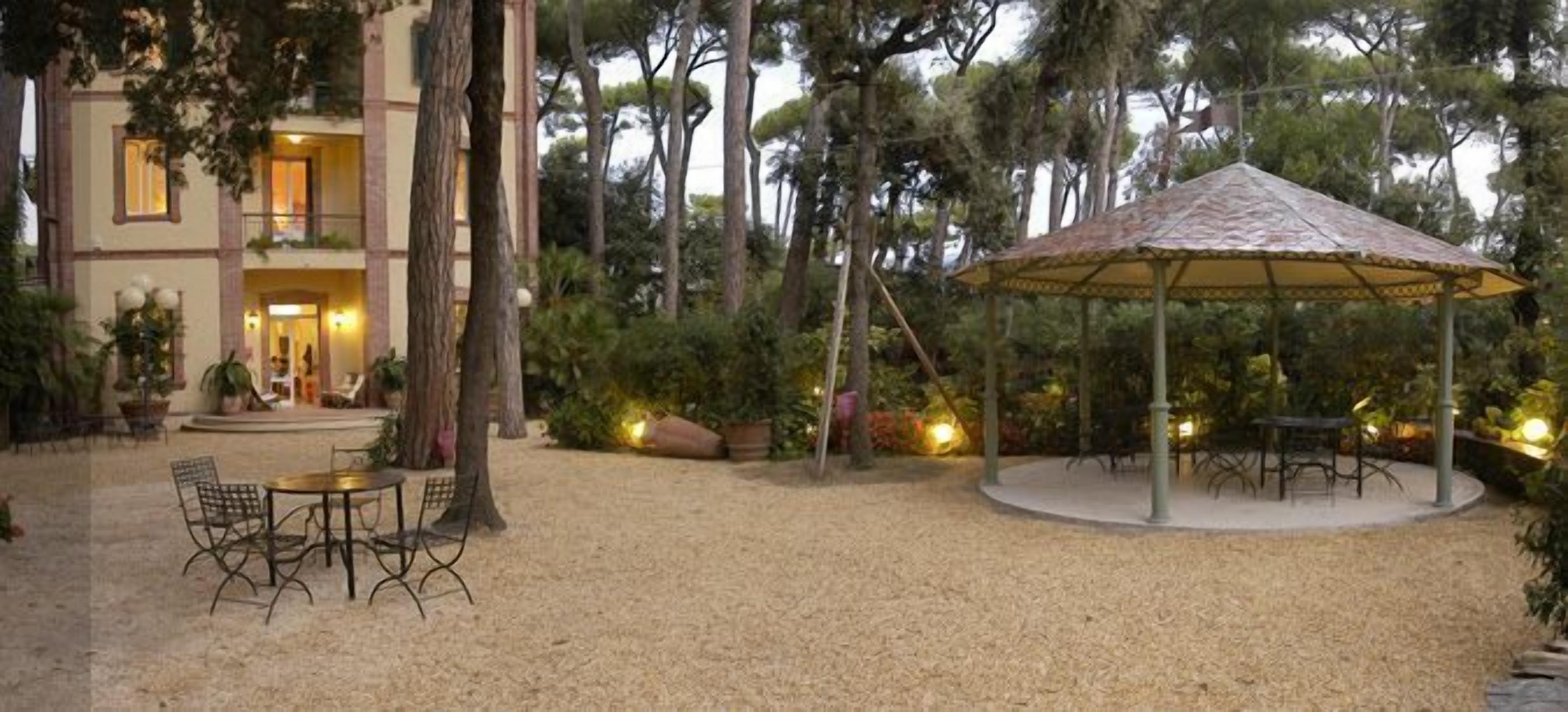 A courtyard with a gazebo, outdoor seating, and a building entrance.