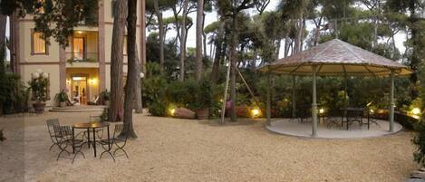 A courtyard with a gazebo, outdoor seating, and a building entrance.