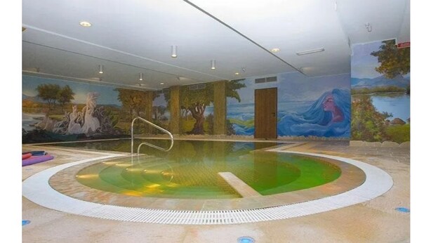 An indoor swimming pool with a mural on the wall depicting a natural landscape. - La Madonnina (Budduso)