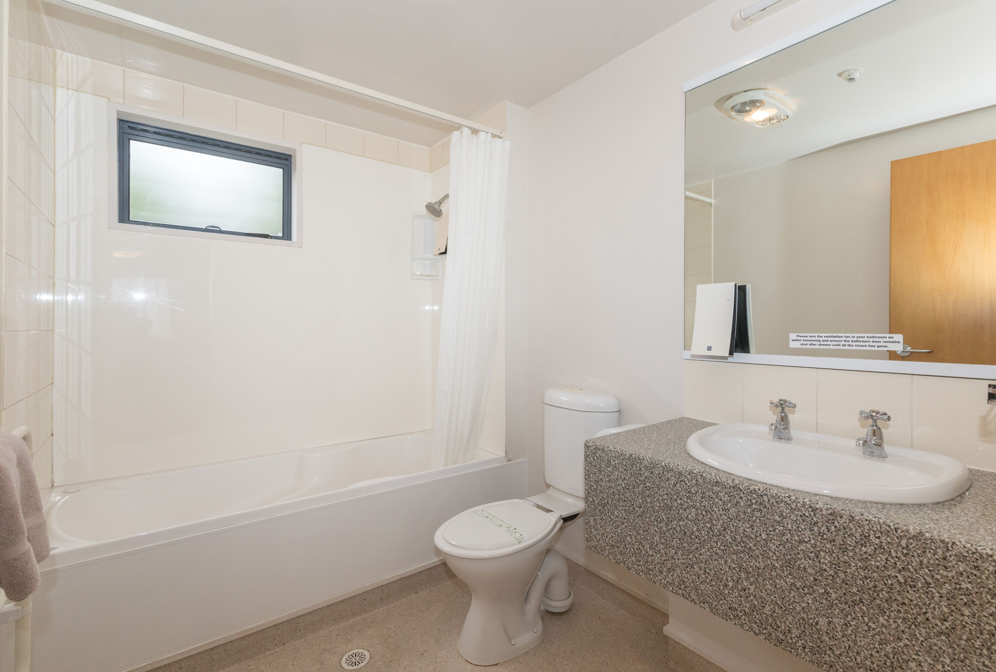 A bathroom with a bathtub, toilet, and sink.