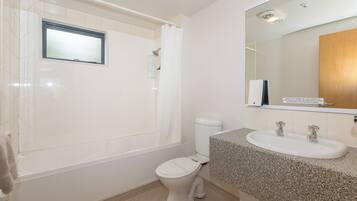 A bathroom with a bathtub, toilet, and sink.