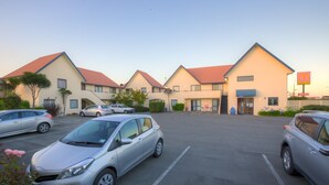 A parking lot with several cars, a McDonald's restaurant, and a building with a red roof. - Bella Vista Motel Oamaru (Oamaru)