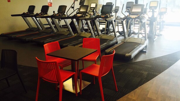 A gym with multiple treadmills, red chairs, and a table. - Bella Vista Motel Oamaru (Oamaru)