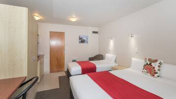 Ett hotellrum med två sängar, ett skrivbord och en garderob.