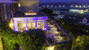 A hotel with a terrace area, outdoor seating, and a view of the surrounding landscape. - La Fregate Hotel (St. Peter Port)