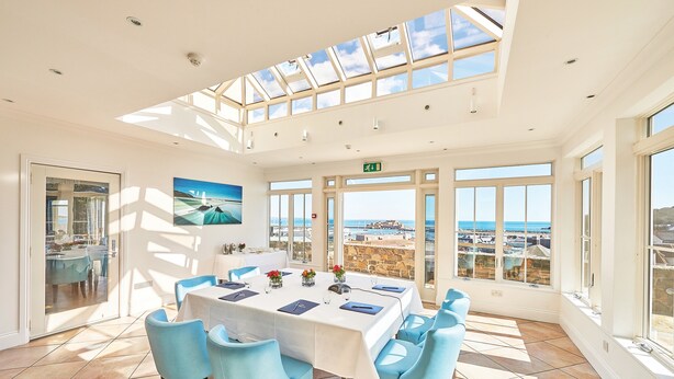 A spacious dining area with a high ceiling and large windows offering a view of the sea. - La Fregate Hotel (St. Peter Port)