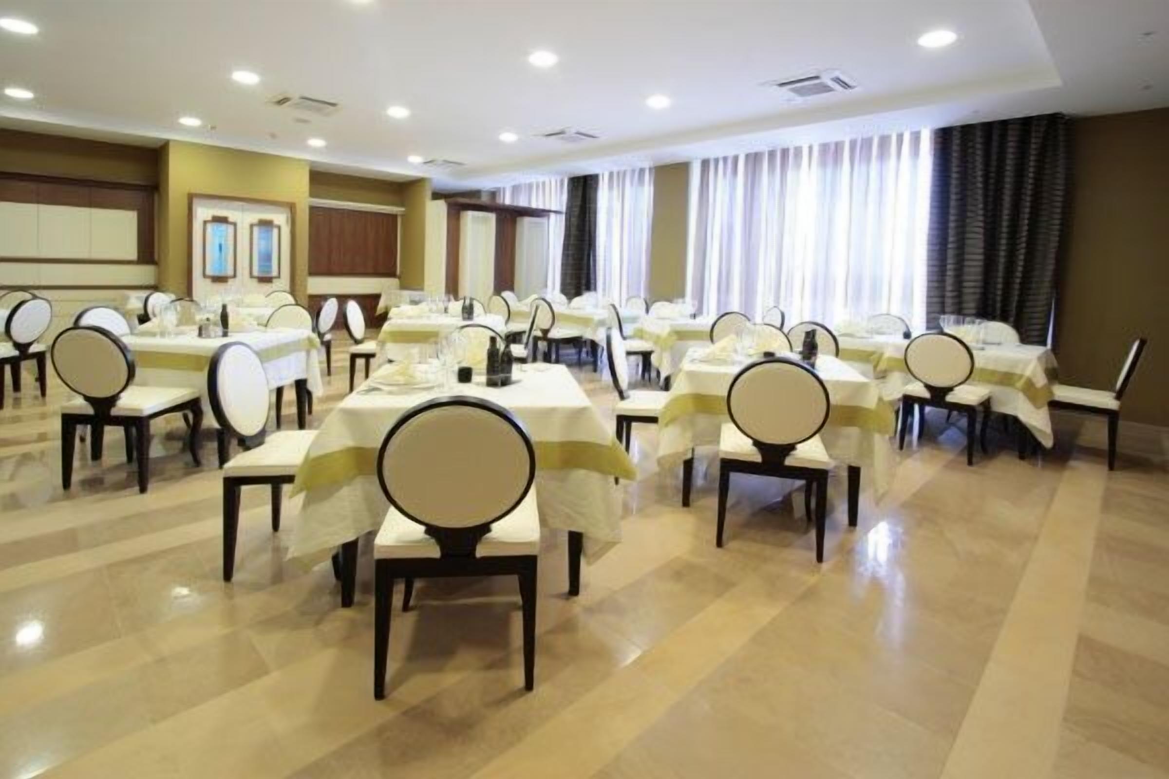 Una sala conferenze con diversi tavoli e sedie disposti in file.