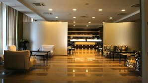 A spacious lobby with a polished floor, seating areas, and a bar in the background. - Tenuta Inagro (San Severo)