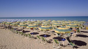 A beach with rows of sunbeds and umbrellas, some with 'HOTEL GIADA' branding. - Hotel Giada (Silvi)