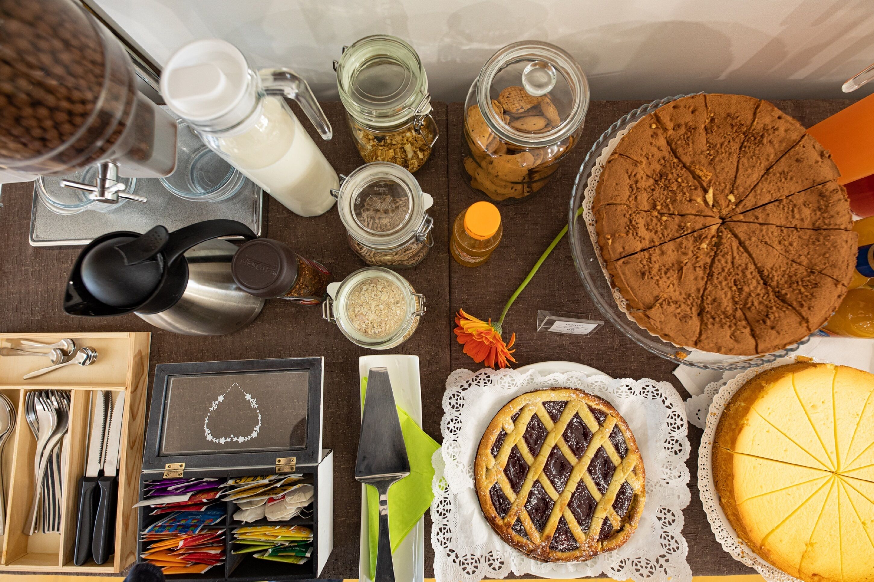 A table with various food items, including a pie, a cake, and jars of ingredients.