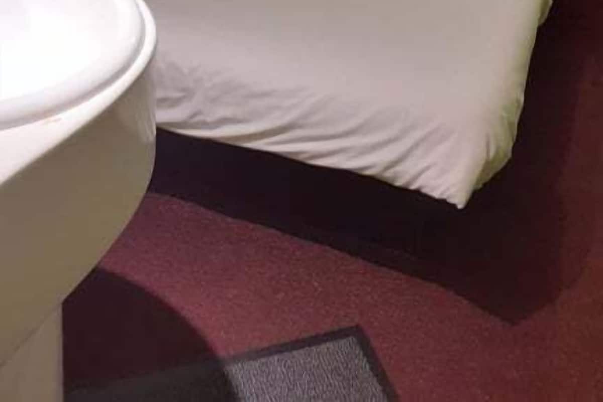 Une chambre d’hôtel équipée d’un lit, d’un bureau, d’une chaise, d’une télévision et d’une petite table.