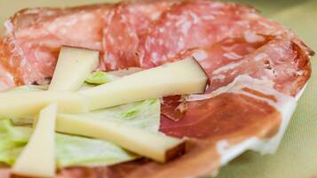 Un piatto di salumi, formaggio e lattuga.