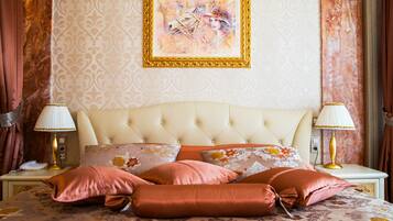 Un dormitorio con cabecera capitonada, ropa de cama con estampado floral y dos lámparas de noche.