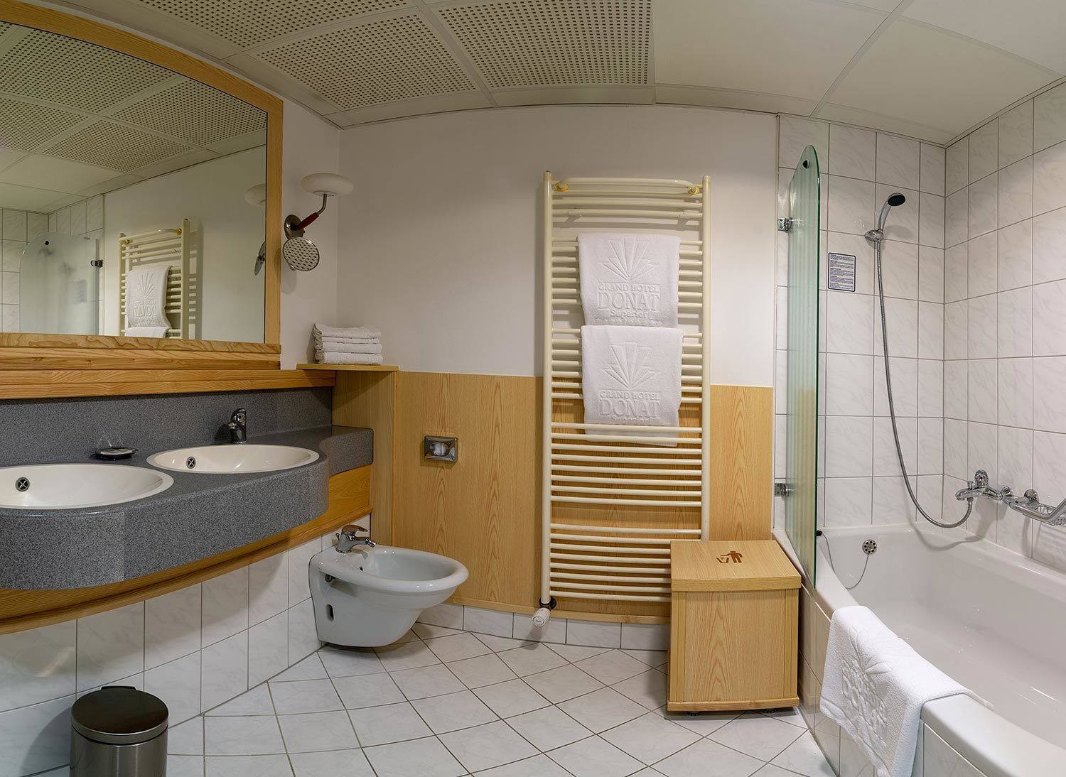 A modern bathroom with two sinks, a bidet, a shower, and a bathtub.