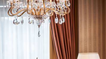 Un comedor con una lámpara de cristal, una mesa con velas y una lámpara.