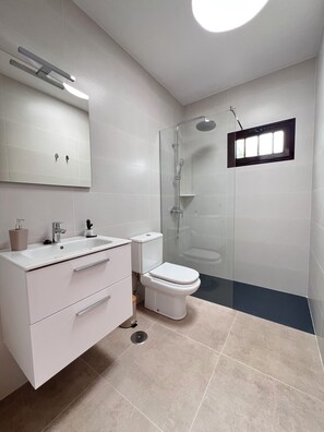 Een douche, handdoeken, toiletpapier