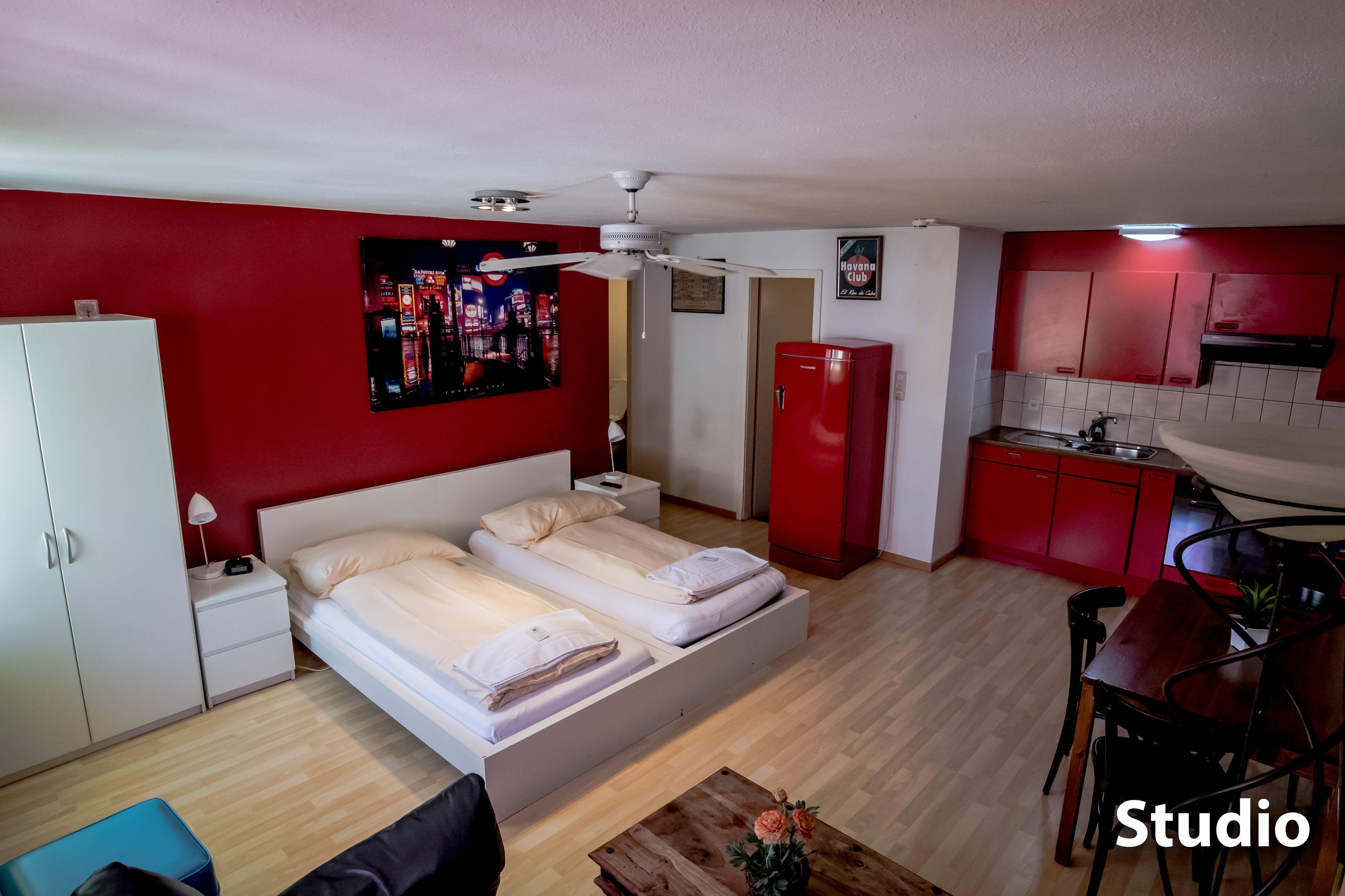 Un apartamento estudio con cama, kitchenette y comedor.