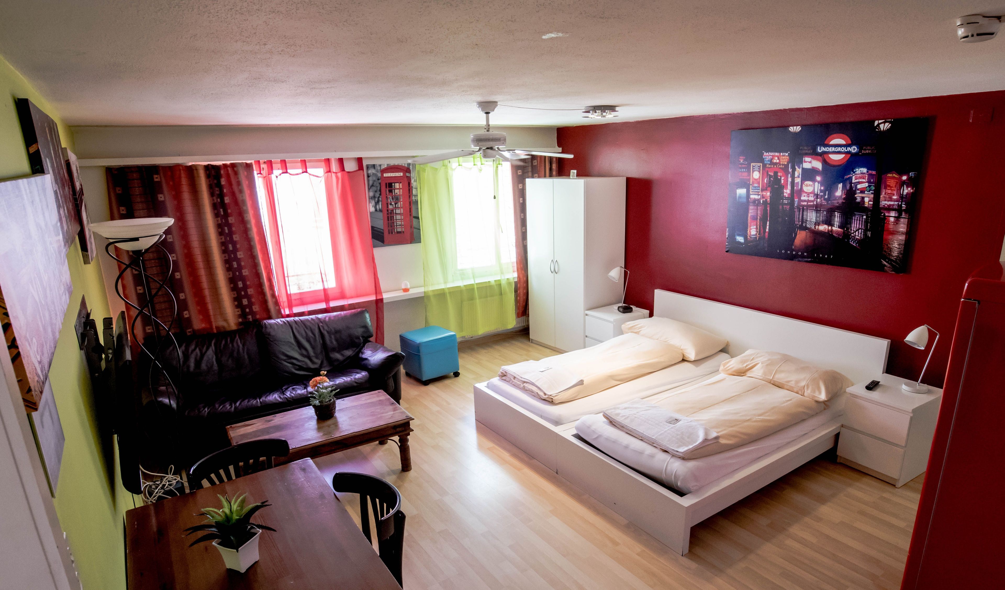 A compact bedroom with a bed, bedside tables, a desk, and a chair.