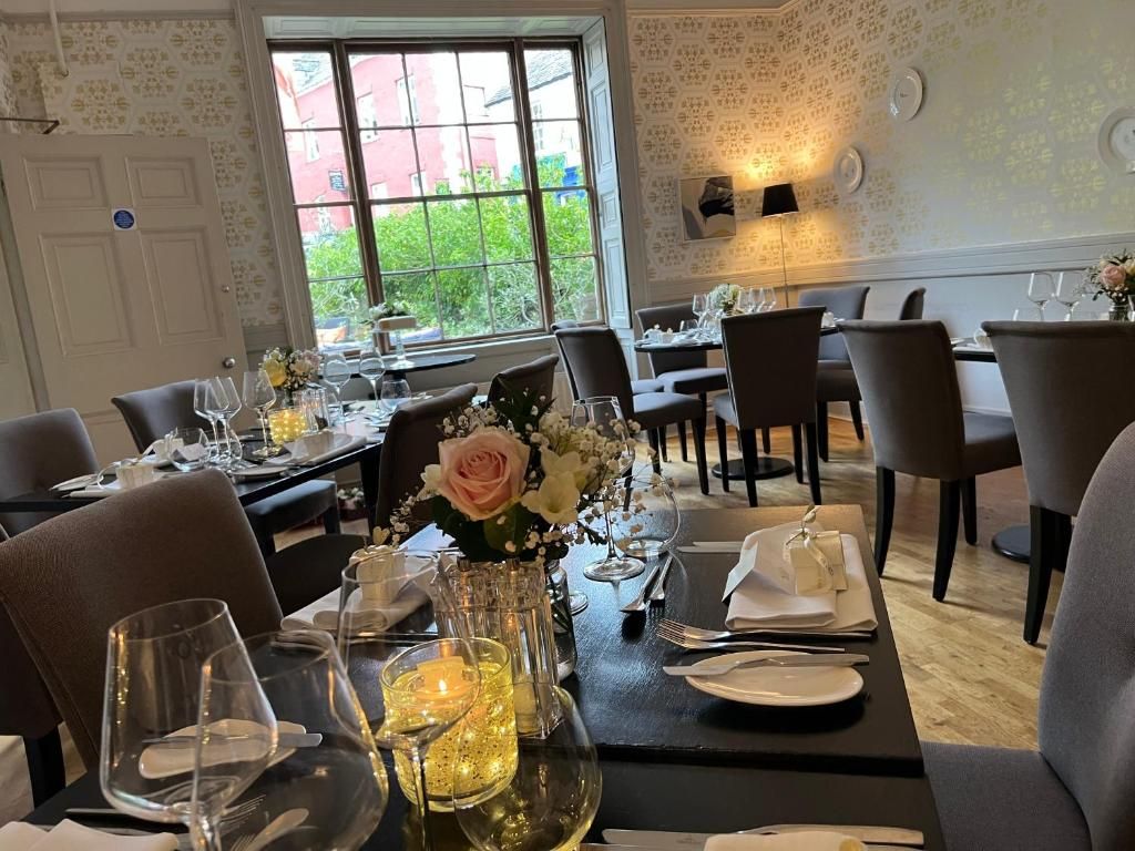 A dining area with tables set for a meal, featuring clear glassware, plates, and cutlery.