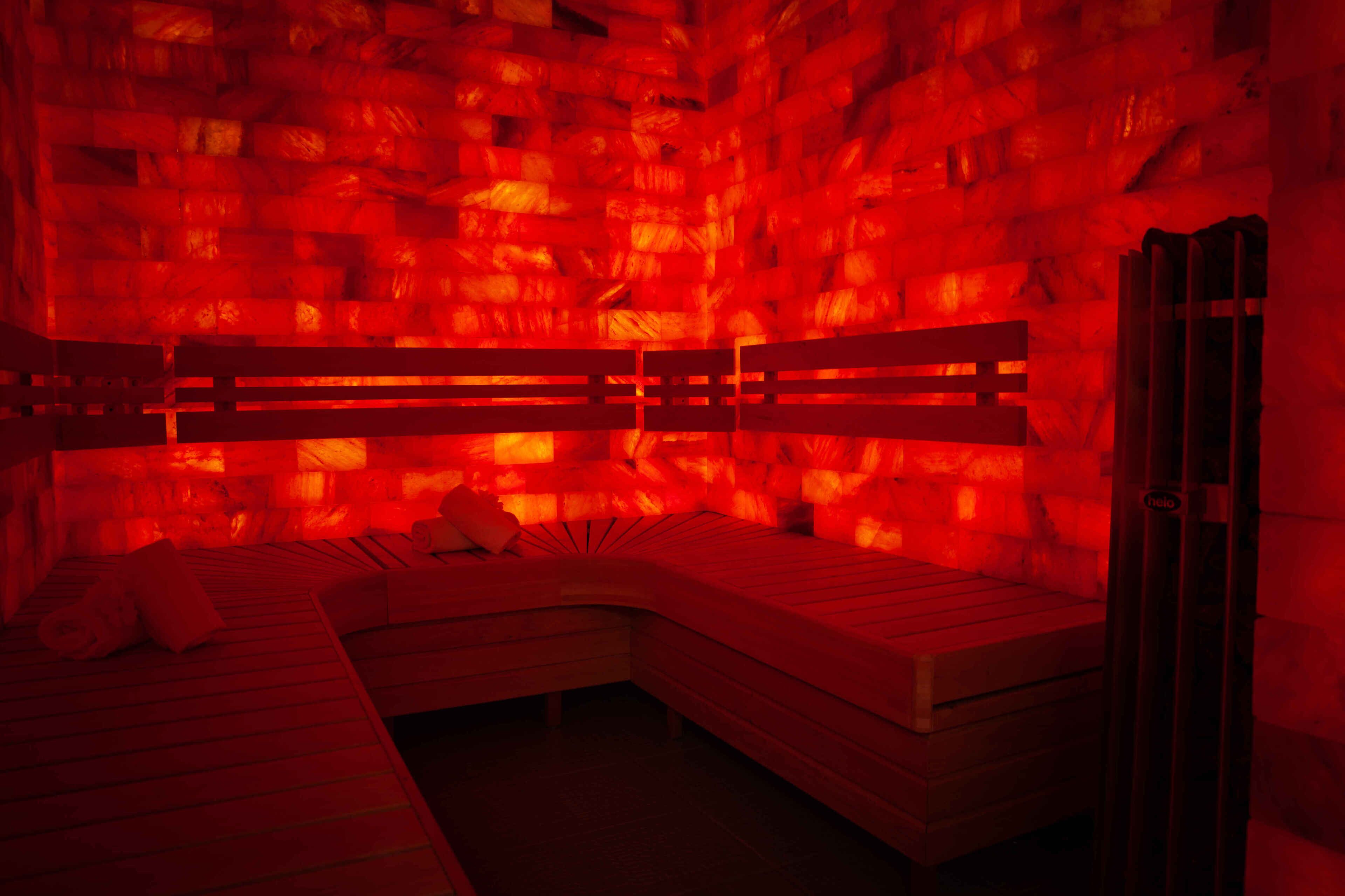 A room with a curved wooden bench, a small table, and a door.