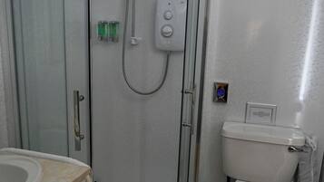 A modern bathroom with a glass-enclosed shower, a toilet, and a sink.