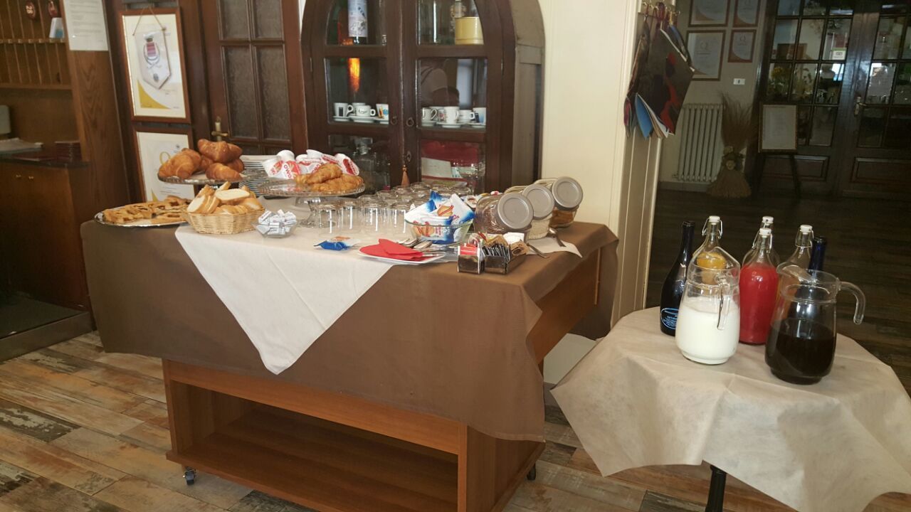 Une table de buffet garnie de divers plats, de verres et de bouteilles de boissons.