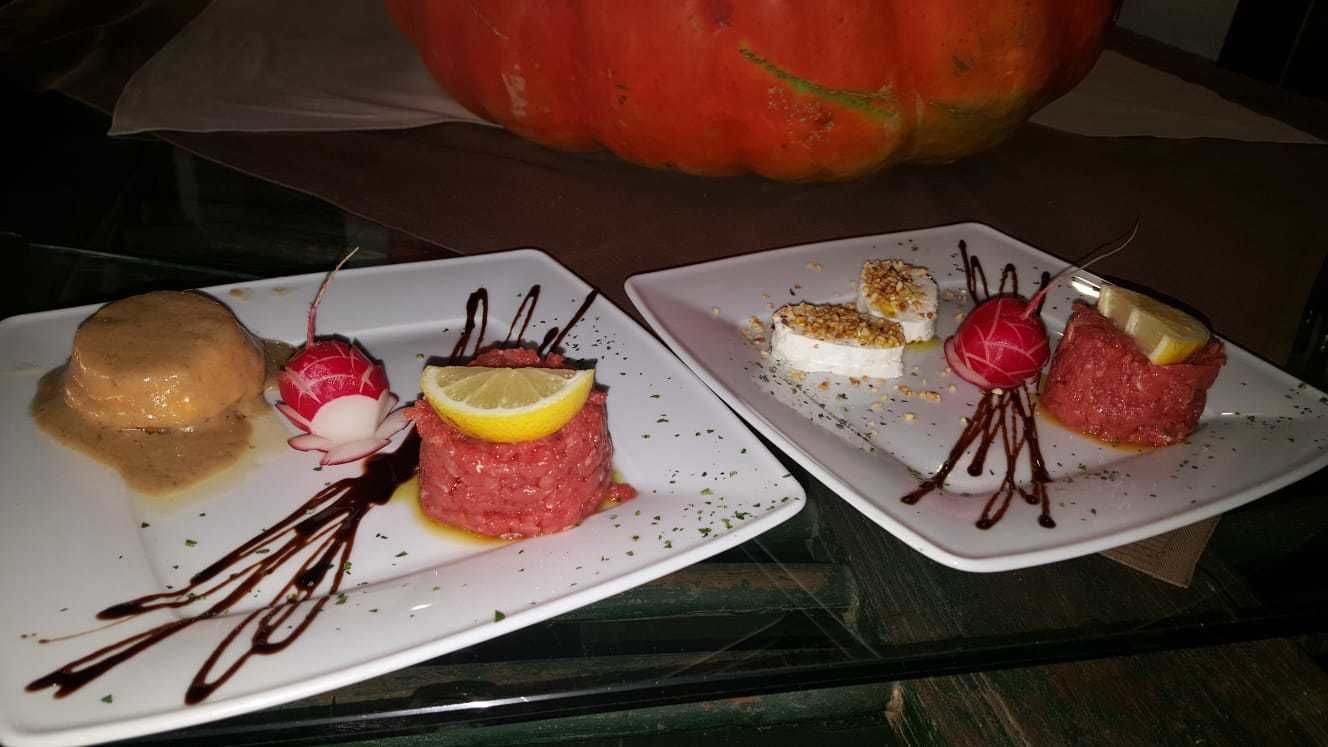 Deux assiettes de nourriture, avec une citrouille en arrière-plan.