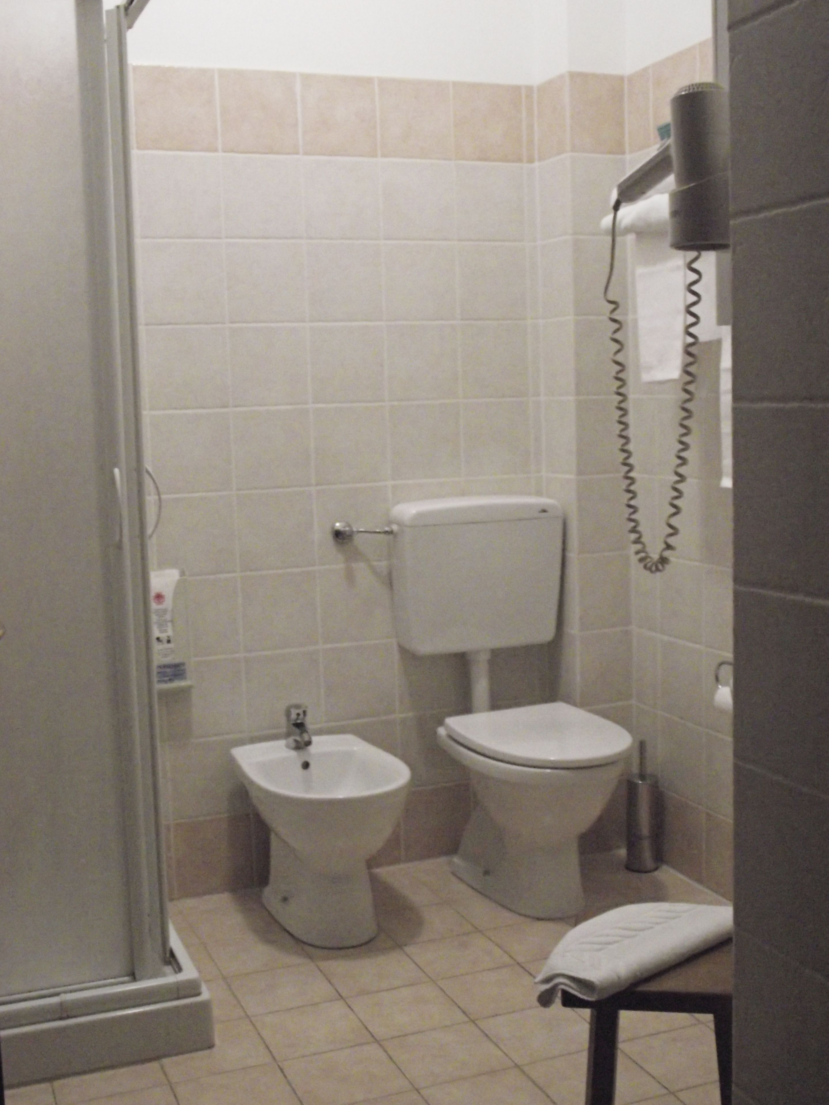 Un baño con ducha, bidé e inodoro.