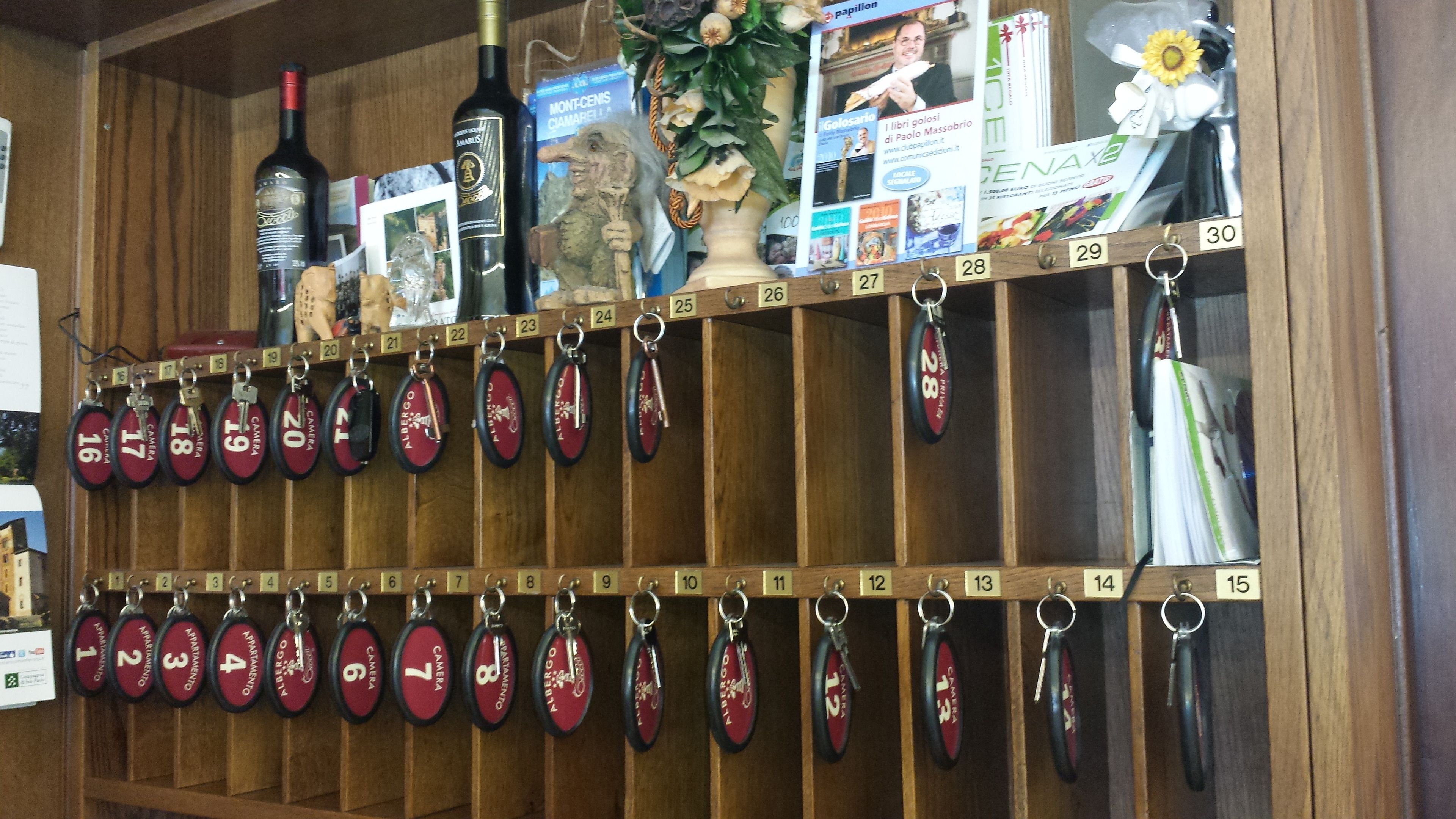 A hotel room with wooden paneling, a minibar, and a wall-mounted key rack with numbered key holders.