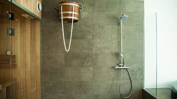 A modern bathroom with a wooden vanity, a shower with a rain showerhead, and a wooden bucket-style sink.