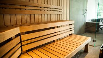 A wooden bench with a slatted design, positioned in a room with a glass door leading to an outdoor area.