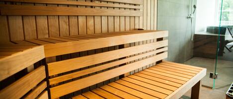 A wooden bench with a slatted design, positioned in a room with a glass door leading to an outdoor area.