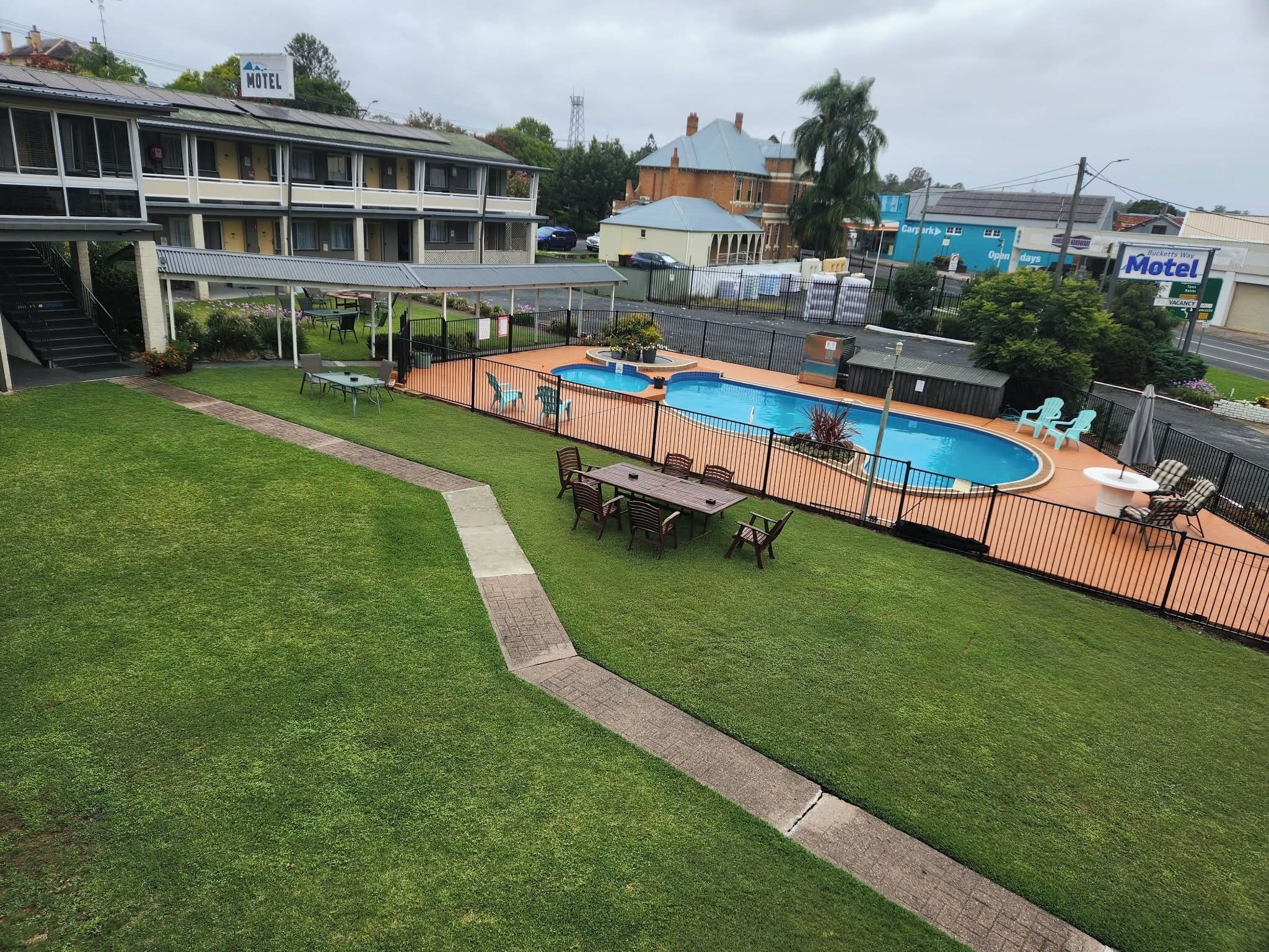 Een motel met een zwembad, buiten zitplaatsen en een overdekt terras.