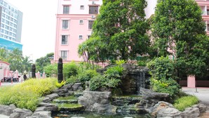 A landscaped garden with a small waterfall and rock formations. - Jack's CondoApartment @ Marina Court Resort Condominium (Kota Kinabalu)