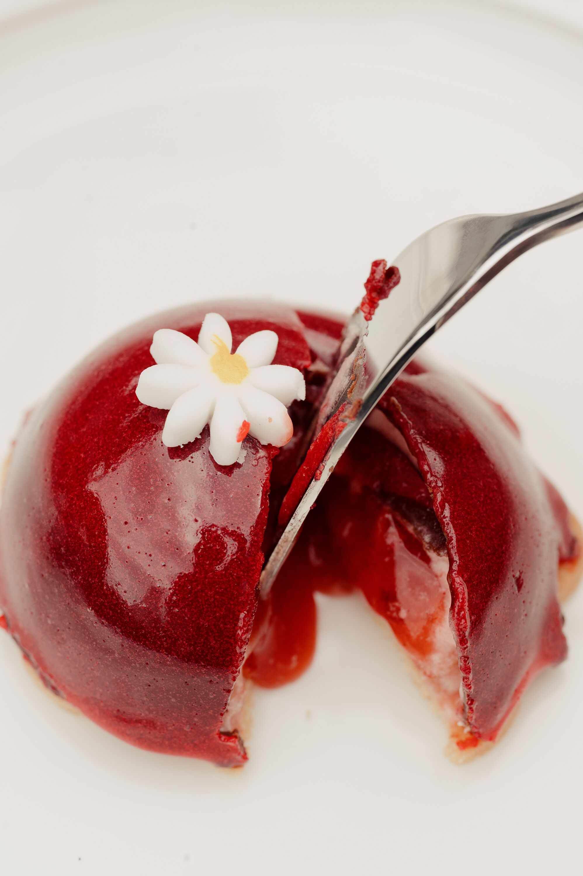 A dessert with a white flower on top, served on a white plate.