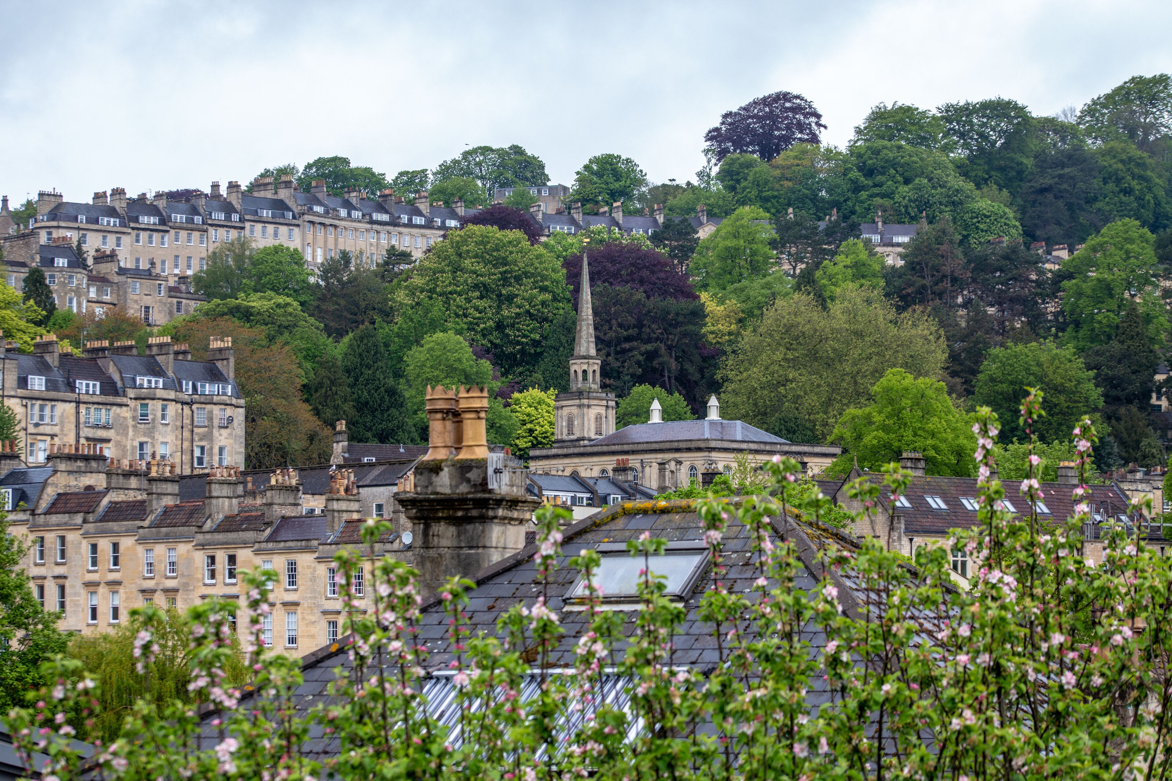 A historic town with traditional architecture, including a prominent church spire and a stone monument.