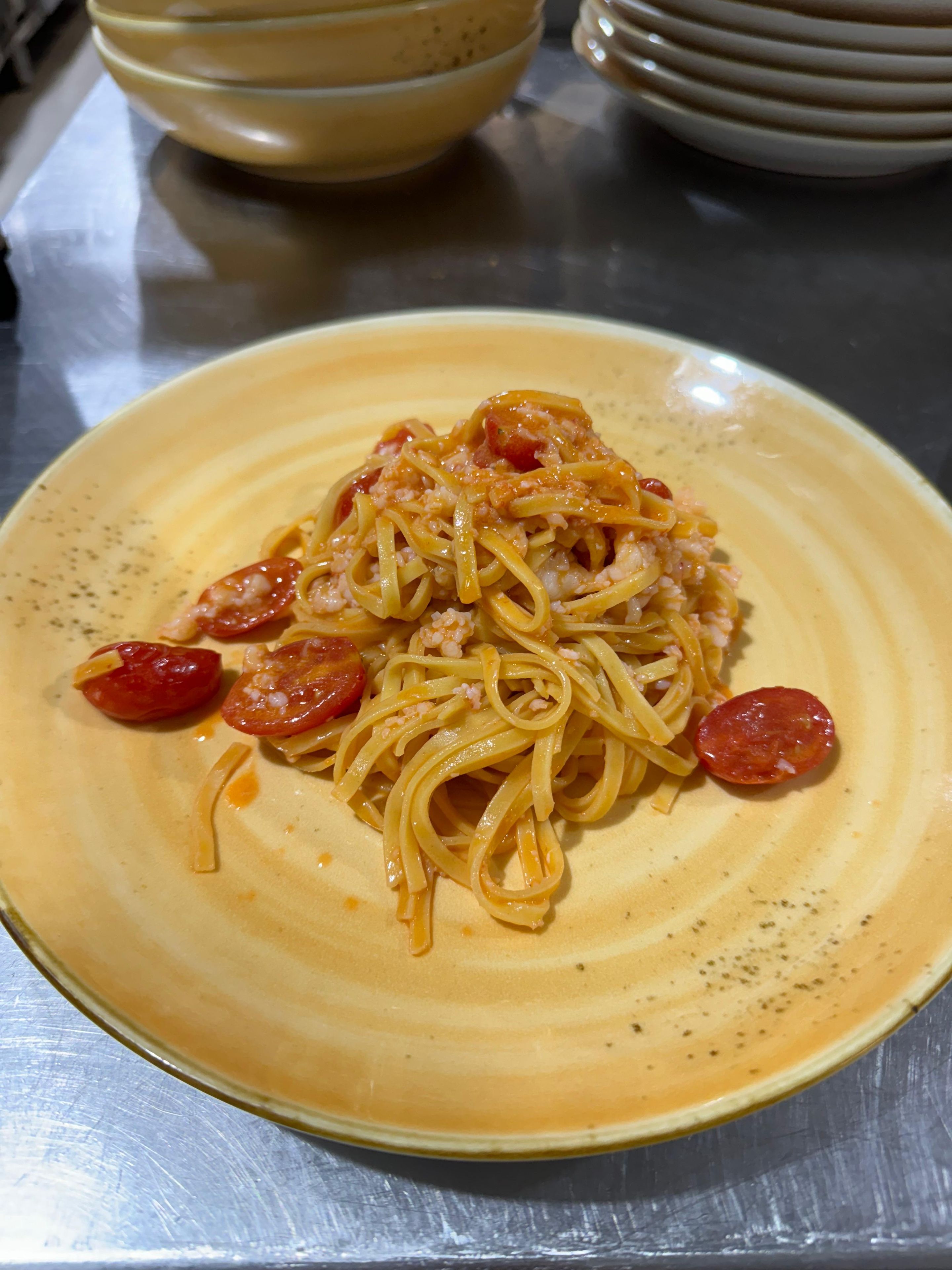 Un plato de espagueti con salsa de tomate y rodajas de salchicha.