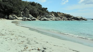 In Strandnähe, weißer Sandstrand, Liegestühle, Sonnenschirme