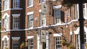 Un edificio de ladrillo de varios pisos con un letrero de pub que dice "The Swan".