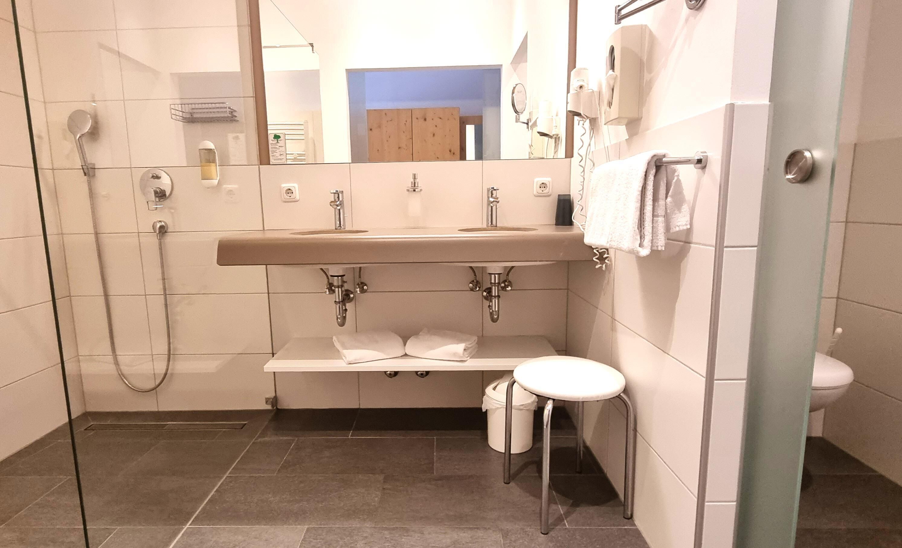 Un baño moderno con ducha, lavamanos e inodoro.
