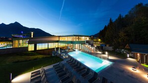 A modern hotel with a swimming pool, outdoor seating, and mountain views. - Hotel Goldene Rose (Lechaschau)