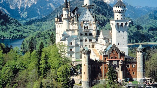 A large, historic castle with multiple towers and a lake in the background. - Hotel Goldene Rose (Lechaschau)