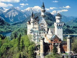 A large, historic castle with multiple towers and a lake in the background. - Hotel Goldene Rose (Lechaschau)