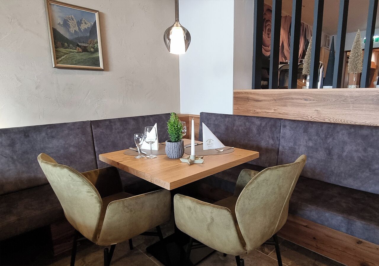 A corner seating area with a wooden table and cushioned chairs.