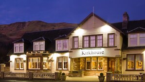 Un edificio tradicional con un letrero que dice "Kirkhouse" en la entrada, con varias ventanas y fachada de piedra.