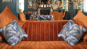 Una sala de estar acogedora con un sofá naranja cómodo, cojines decorativos y una chimenea.