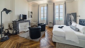 Un dormitorio moderno con una cama grande, un escritorio con televisor y vistas al exterior.