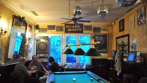 A billiards room with a pool table, a dartboard, and a foosball table. - Hotel & Backpackers Zak (Neuhausen am Rheinfall)